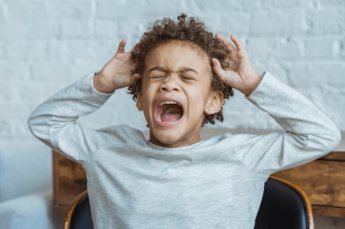 Kid holding head crying